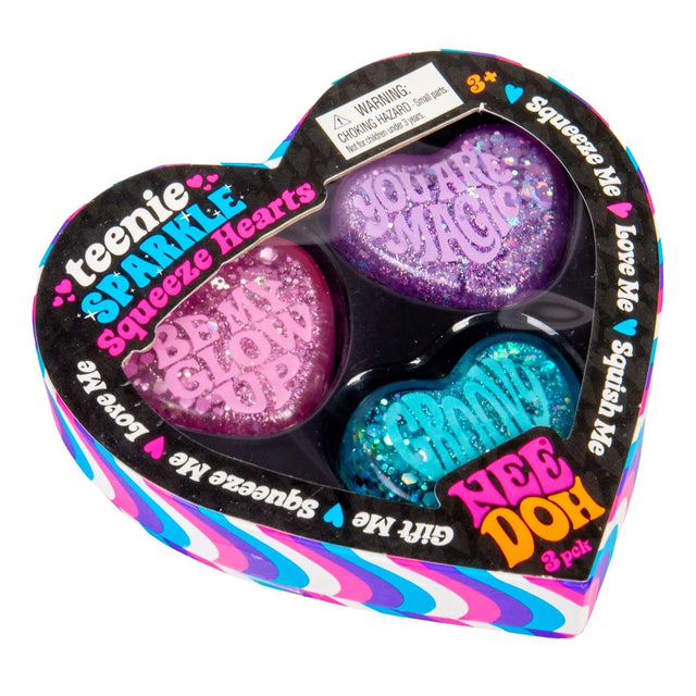 Heart-shaped packaging features three glittery squeeze hearts in pink, purple, and blue with phrases like "YOU ARE MAGIC." The colorful design is playful and inviting.