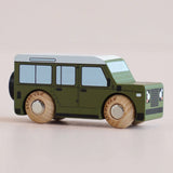 Side view of a green wooden toy car with a white roof and natural wood wheels.
