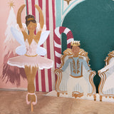 Paper cutout of a fairy ballerina dancing next to a prince figure seated on a golden throne.