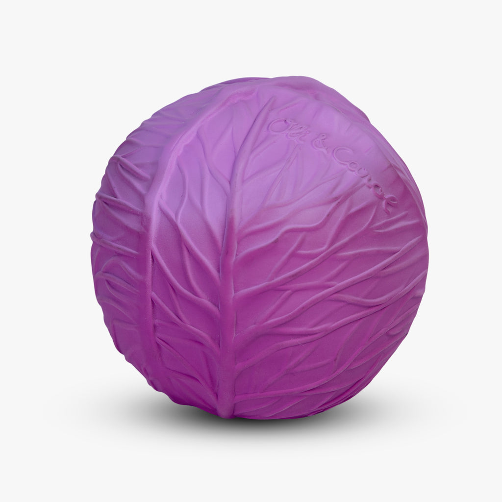 A vibrant purple ball resembling a cabbage, with textured lines mimicking leaves. The surface includes subtle lettering, creating a playful and whimsical tone.