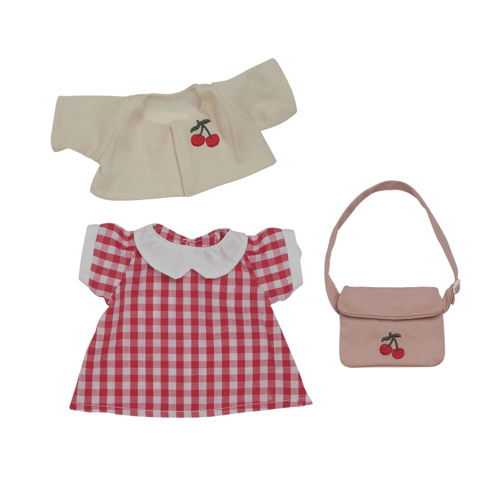 Red and white checkered doll dress with a white collar, cream sweater with cherry embroidery, and a pink bag on a white background. Cute and playful.