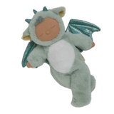 Plush baby doll in a green dragon onesie with sparkly wings and horns. The doll's eyes are closed, and it conveys a peaceful, sleepy expression.
