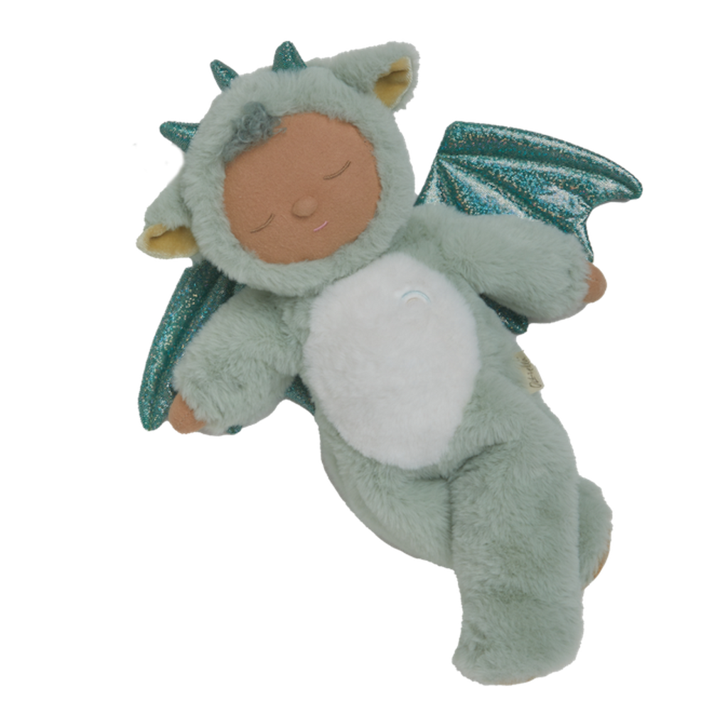 Plush baby doll in a green dragon onesie with sparkly wings and horns. The doll's eyes are closed, and it conveys a peaceful, sleepy expression.