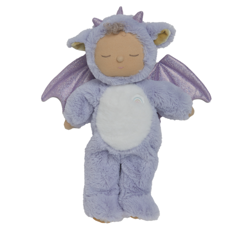 Cute plush doll in a purple dragon costume with sparkly wings. The doll has a serene expression, curly hair, and a small rainbow emblem.
