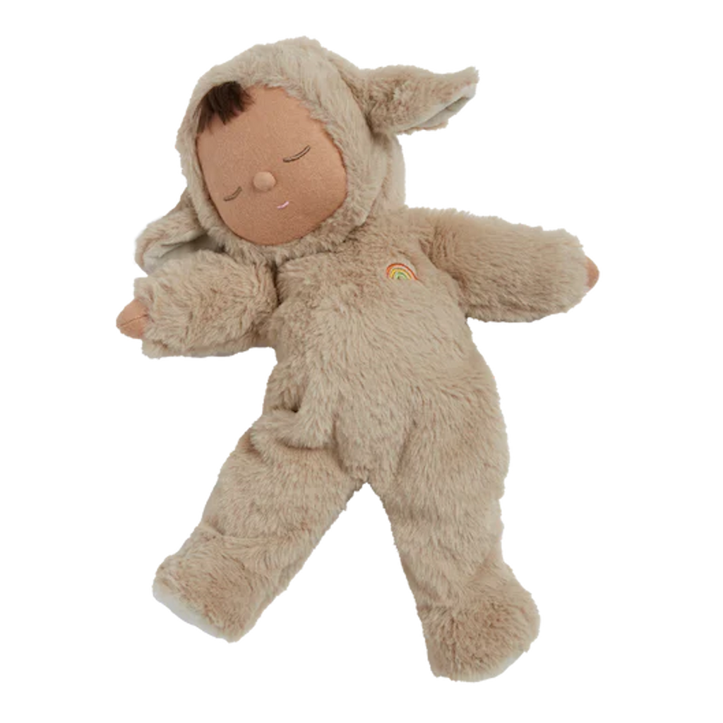 Cute doll in a fluffy beige sheep costume with floppy ears and a serene face. The doll wears a small embroidered rainbow, conveying calmness.