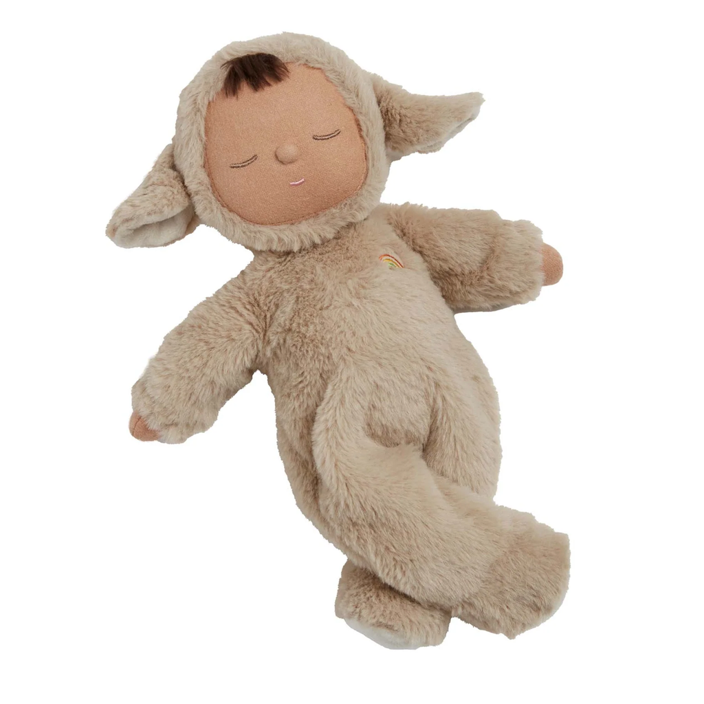 Cute doll in a fluffy beige sheep costume with floppy ears and a serene face. The doll wears a small embroidered rainbow, conveying calmness.