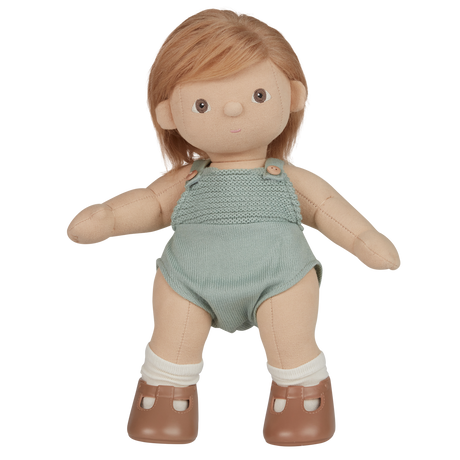 A plush doll with light brown hair wears a knitted light teal romper and brown shoes with white socks. The expression is neutral, set against a white background.