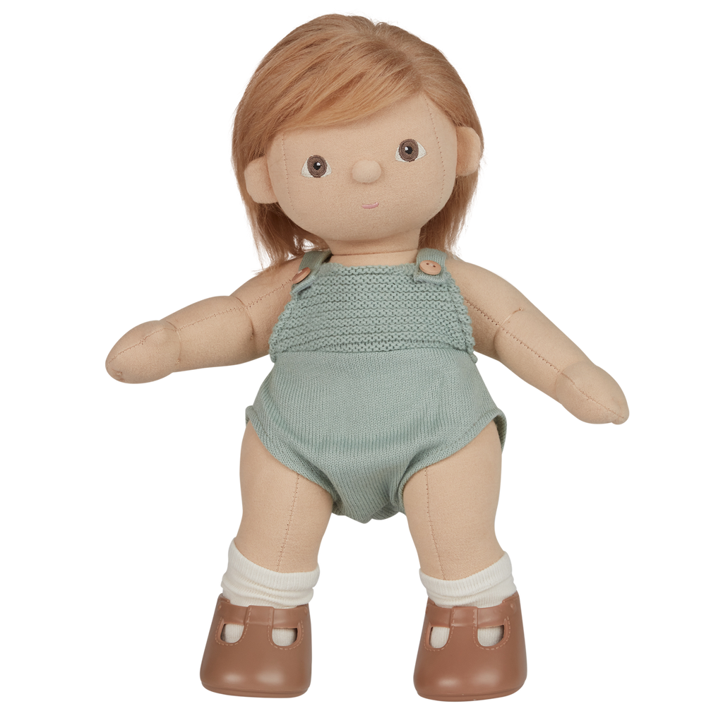 A plush doll with light brown hair wears a knitted light teal romper and brown shoes with white socks. The expression is neutral, set against a white background.