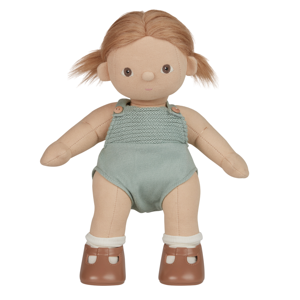 A plush doll with light brown hair wears a knitted light teal romper and brown shoes with white socks. The expression is neutral, set against a white background.