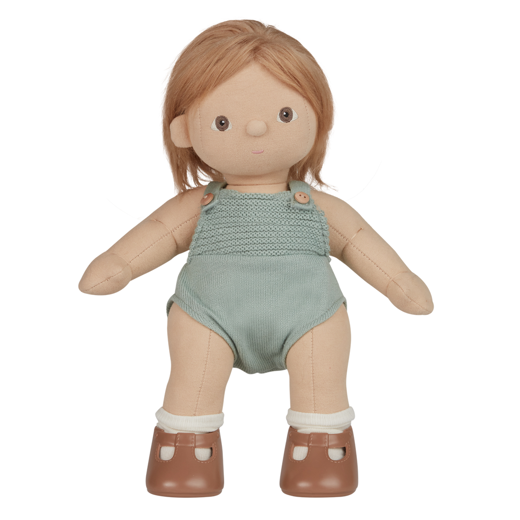 A plush doll with light brown hair wears a knitted light teal romper and brown shoes with white socks. The expression is neutral, set against a white background.