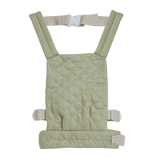Quilted sage doll carrier with adjustable straps and buckle, displayed against a white background. The carrier has a soft, padded look.
