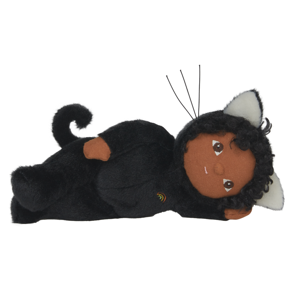 Cuddly doll in a black cat outfit with white ears and embroidered rainbow. It has a gentle expression, sitting against a white background.