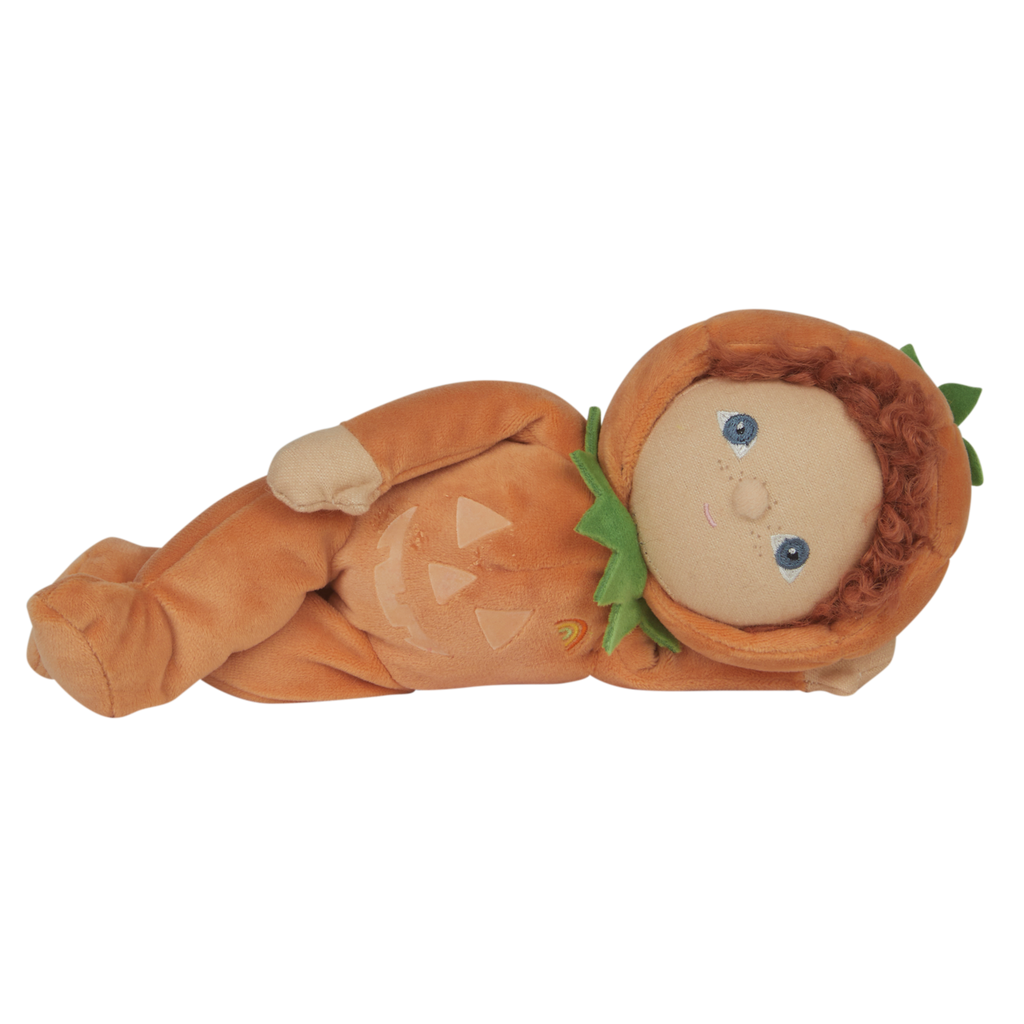Soft doll with curly hair in a pumpkin costume, featuring a green leaf collar and smiling face. The costume has a jack-o'-lantern design and a small rainbow.