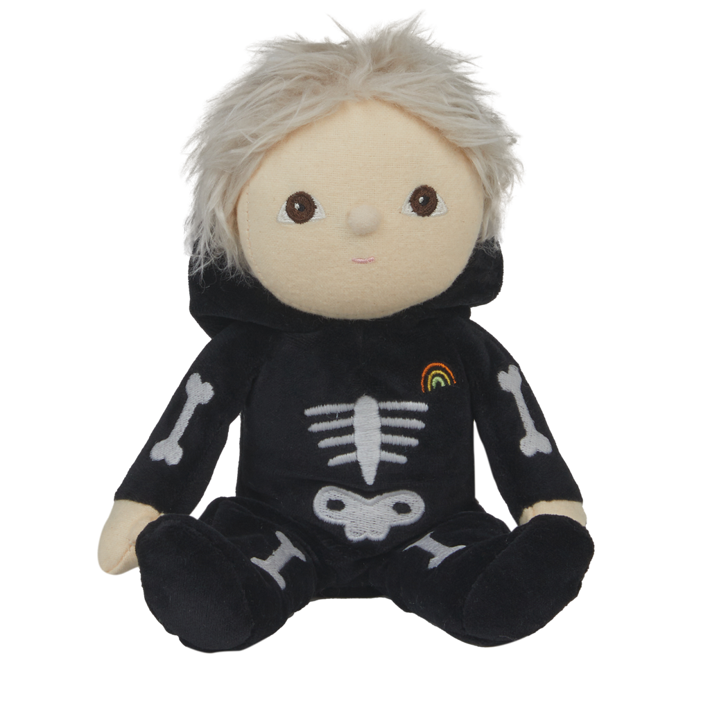 Cute plush doll with light hair in a black skeleton costume, featuring bone designs and a small rainbow patch. The doll has a neutral expression.