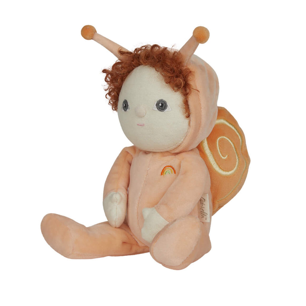Cute plush doll with curly red hair, dressed in a peach snail outfit with antennas and a rainbow emblem. It sits with a sweet, cheerful expression.