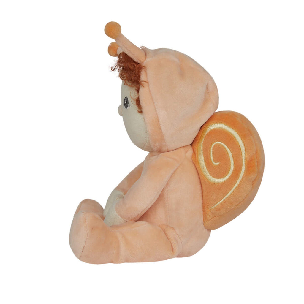 Cute plush doll with curly red hair, dressed in a peach snail outfit with antennas and a rainbow emblem. It sits with a sweet, cheerful expression.