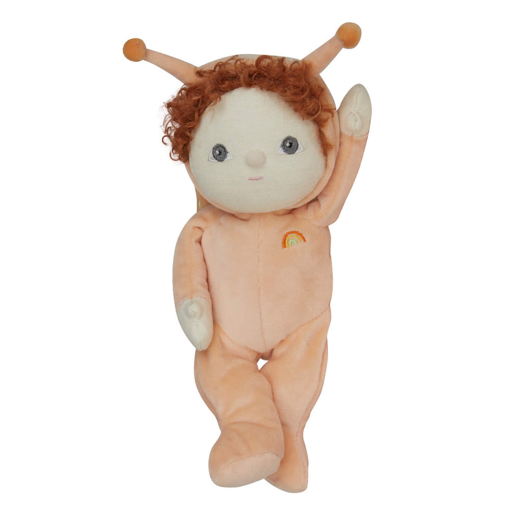 Cute plush doll in a peach hooded onesie with antennae, curly hair, and embroidered rainbow. The doll has a friendly expression and is raising one arm.