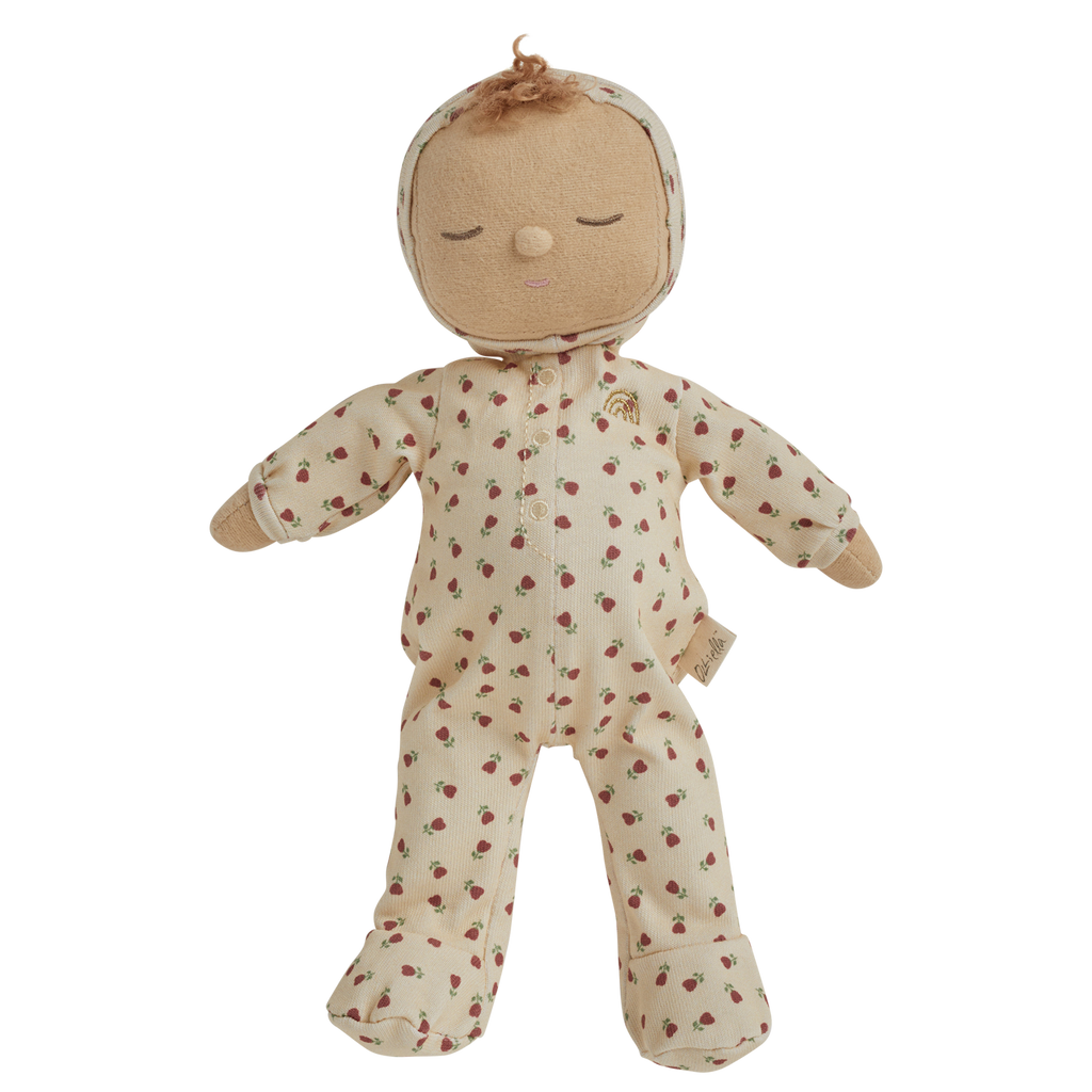 A soft doll in a cream-colored outfit with red strawberry patterns. The doll has closed eyes, curly hair on top, and small mittens and booties.