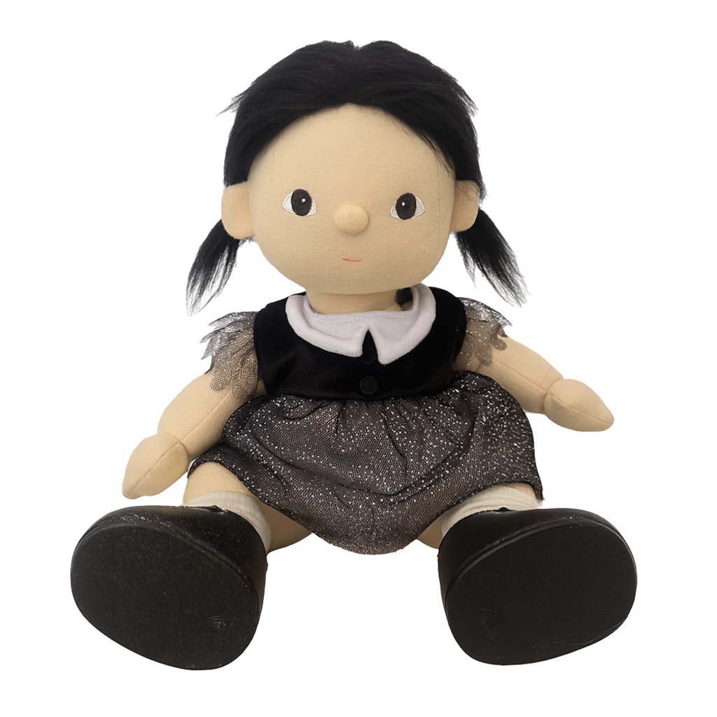 A plush doll dressed as a witch features a pointy black hat with stars, a gray dress, and black shoes. The doll holds a small broom, creating a playful, whimsical tone.