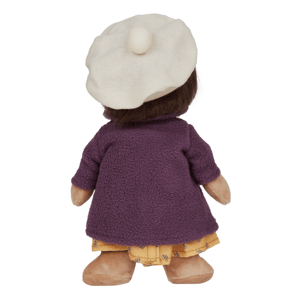 Plush doll with a soft brown face, wearing a cream beret, purple buttoned coat, and yellow dress with patterns, against a white background.