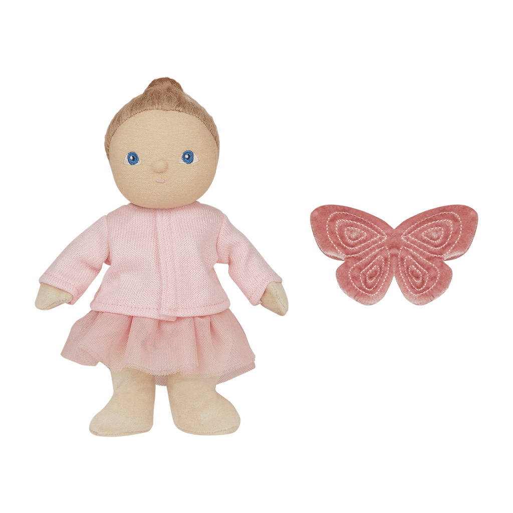 A soft doll in a pink outfit with blue eyes stands next to a plush pink butterfly on a white background, conveying a whimsical tone.