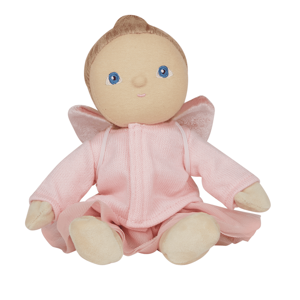 Plush doll with blue eyes and light brown hair, wearing a pink dress with velvet wings. The doll stands against a white background, conveying a whimsical tone.