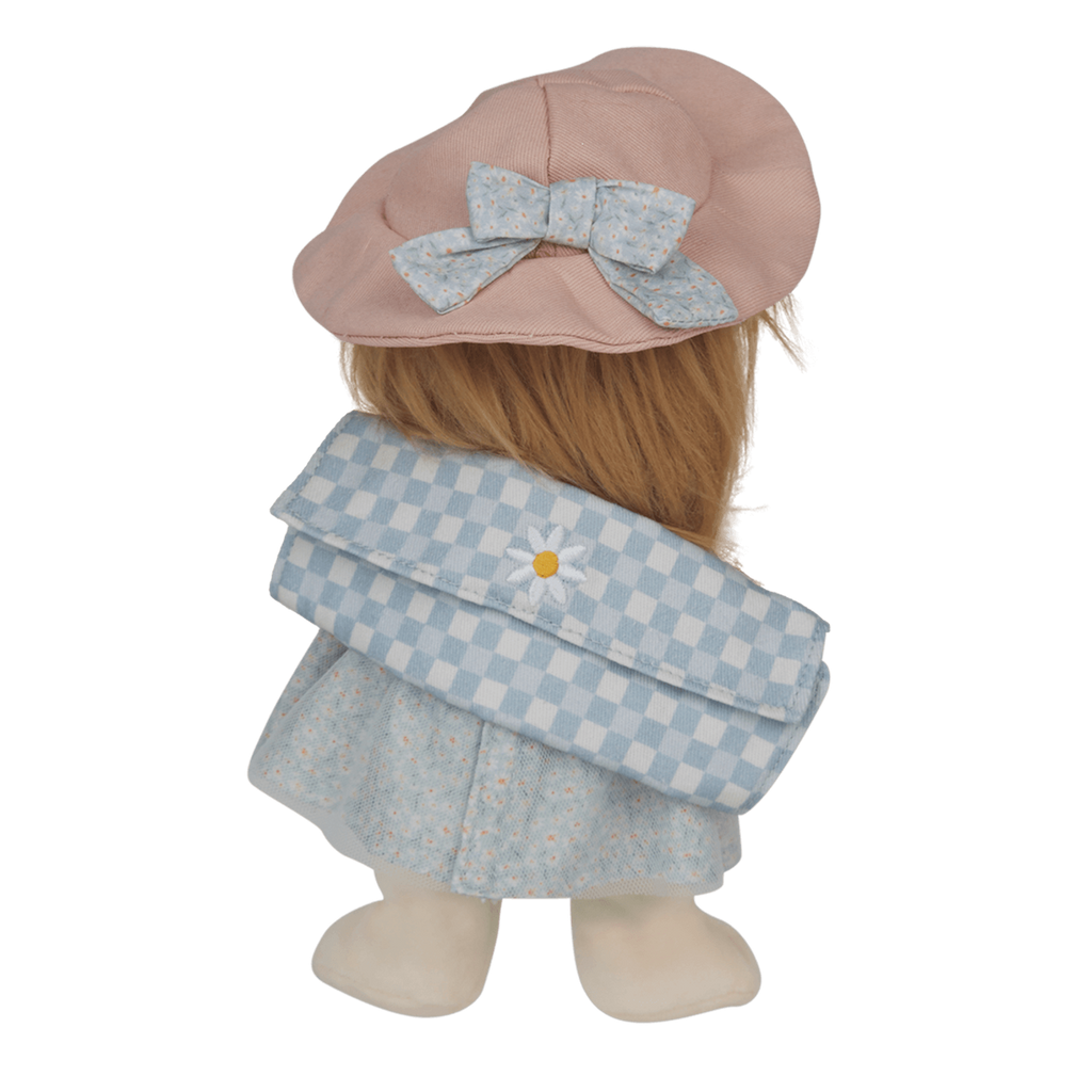 A doll facing away, wearing a pink hat with a blue bow, a blue checkered school bag, and a floral dress. Set against a white background.