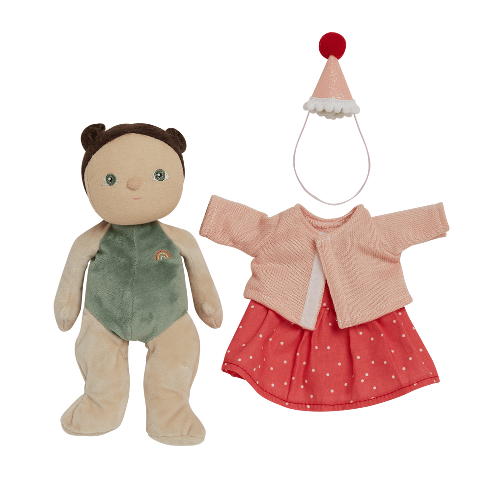 A soft toy with a green outfit and rainbow emblem next to a pink polka-dot dress, cardigan, and cone hat with a red pom-pom on a white background.