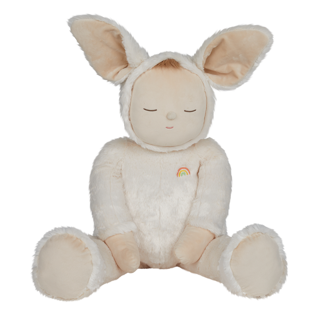 A plush toy with closed eyes, wearing a soft, white bunny suit with large ears. It has a small rainbow patch on its chest, conveying calmness.