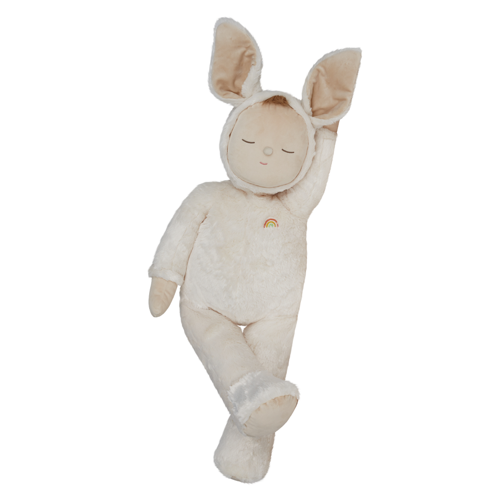 A plush toy with closed eyes, wearing a soft, white bunny suit with large ears. It has a small rainbow patch on its chest, conveying calmness.