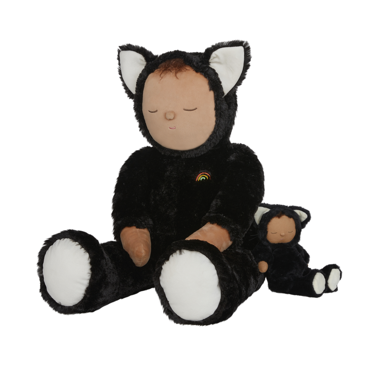 Plush doll dressed as a cat with black fur, white paws and ears, and a tiny rainbow on its chest. The doll's eyes are closed, creating a peaceful expression.