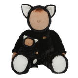 Plush doll dressed as a cat with black fur, white paws and ears, and a tiny rainbow on its chest. The doll's eyes are closed, creating a peaceful expression.
