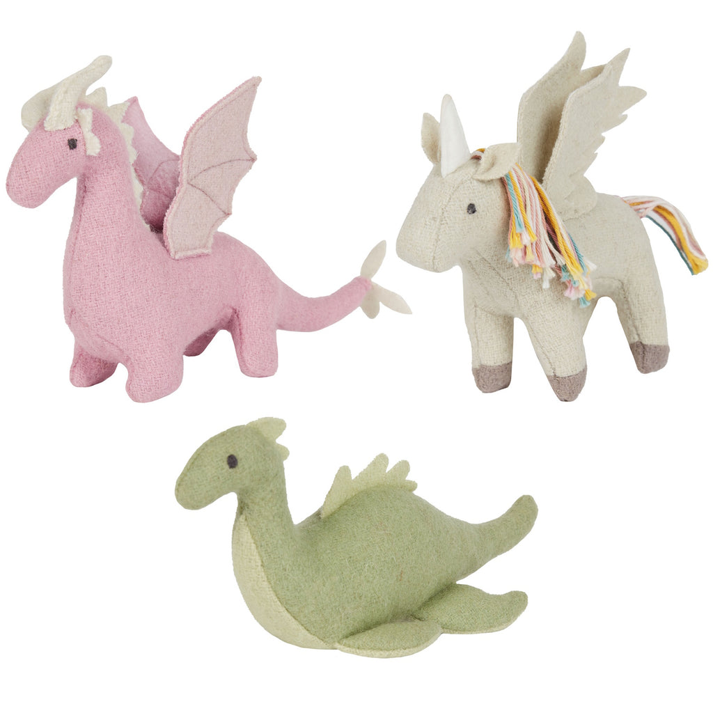 Three whimsical plush toys: a pink dragon, a beige unicorn with colorful mane, and a green dinosaur, each with wings, conveying a playful tone.