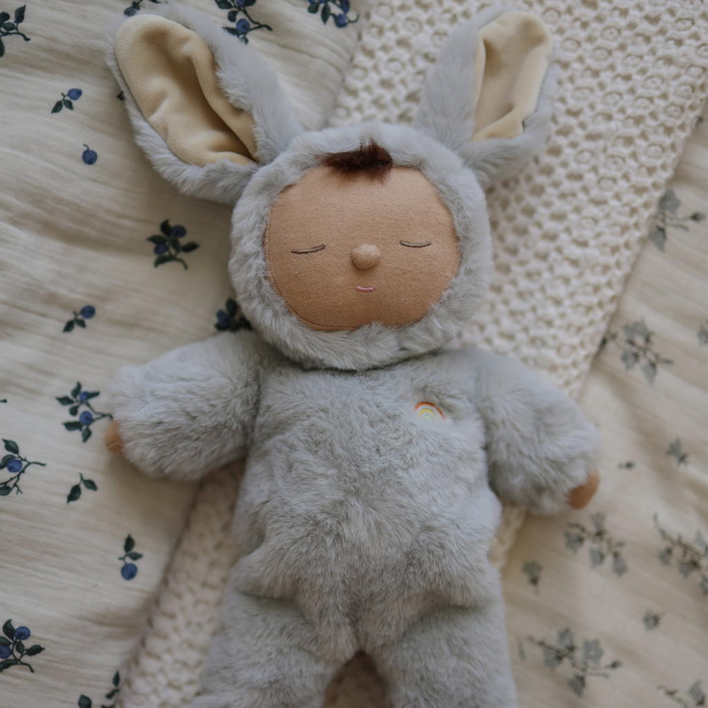 A soft, plush doll wearing a fluffy, gray bunny costume with large ears and a round tail. The doll has a peaceful, sleeping expression.