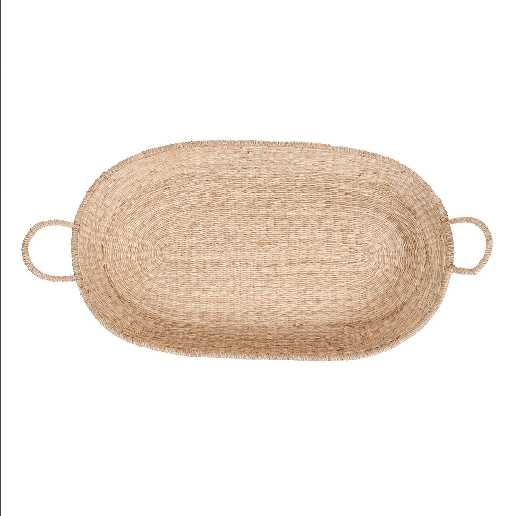 A natural baby changing basket with two loop handles on each side. The basket is oval-shaped, with a simple, rustic texture and a neutral, earthy tone.