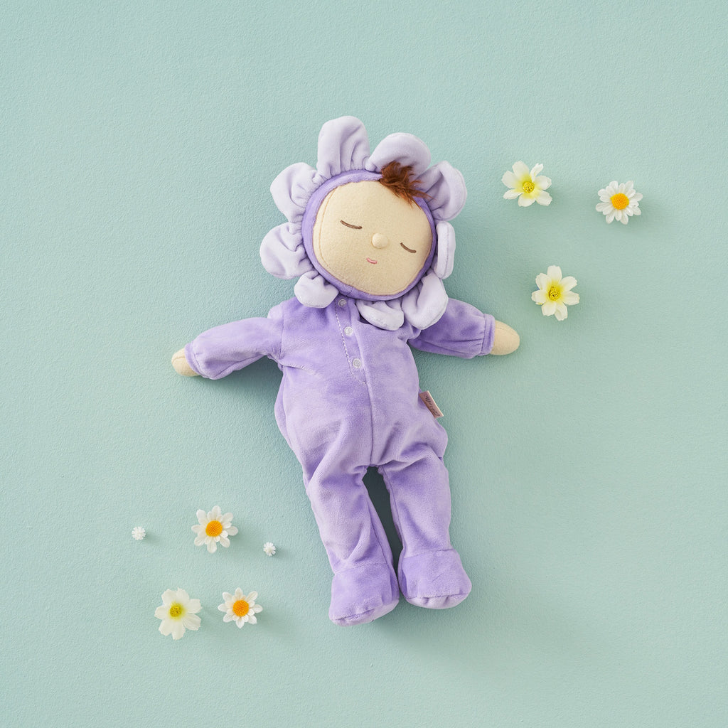 Plush doll with a serene face, dressed in a lavender flower costume, featuring petals around its head, creating a cute and calming tone.