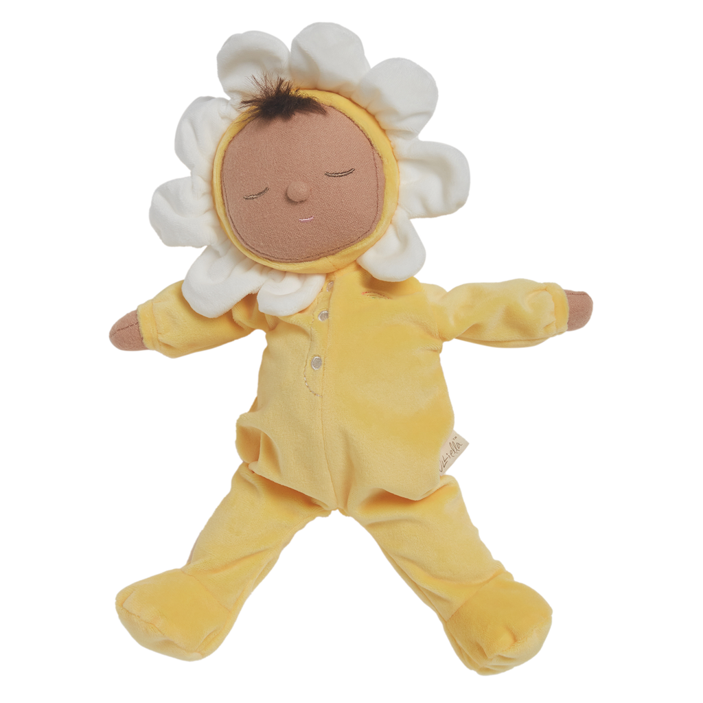 A plush doll with a light brown face framed by white petals, resembling a flower. It wears a soft, yellow bodysuit, conveying a calm, playful vibe.