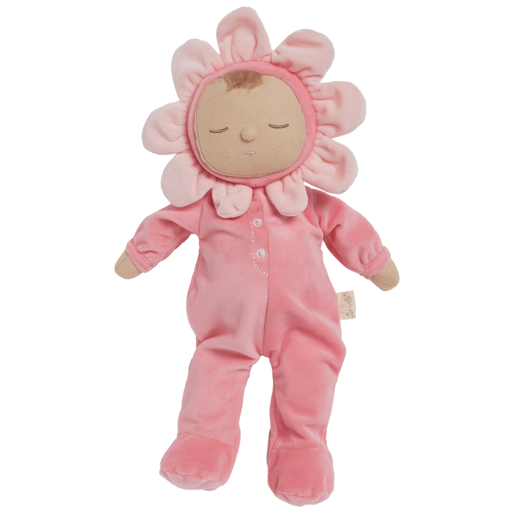 A soft plush toy in a pink floral outfit with closed eyes. The head is encircled by pink petals, evoking a flower. The toy conveys calmness.