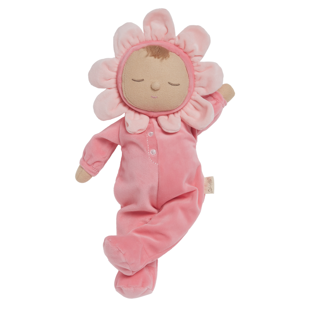 A soft plush toy in a pink floral outfit with closed eyes. The head is encircled by pink petals, evoking a flower. The toy conveys calmness.