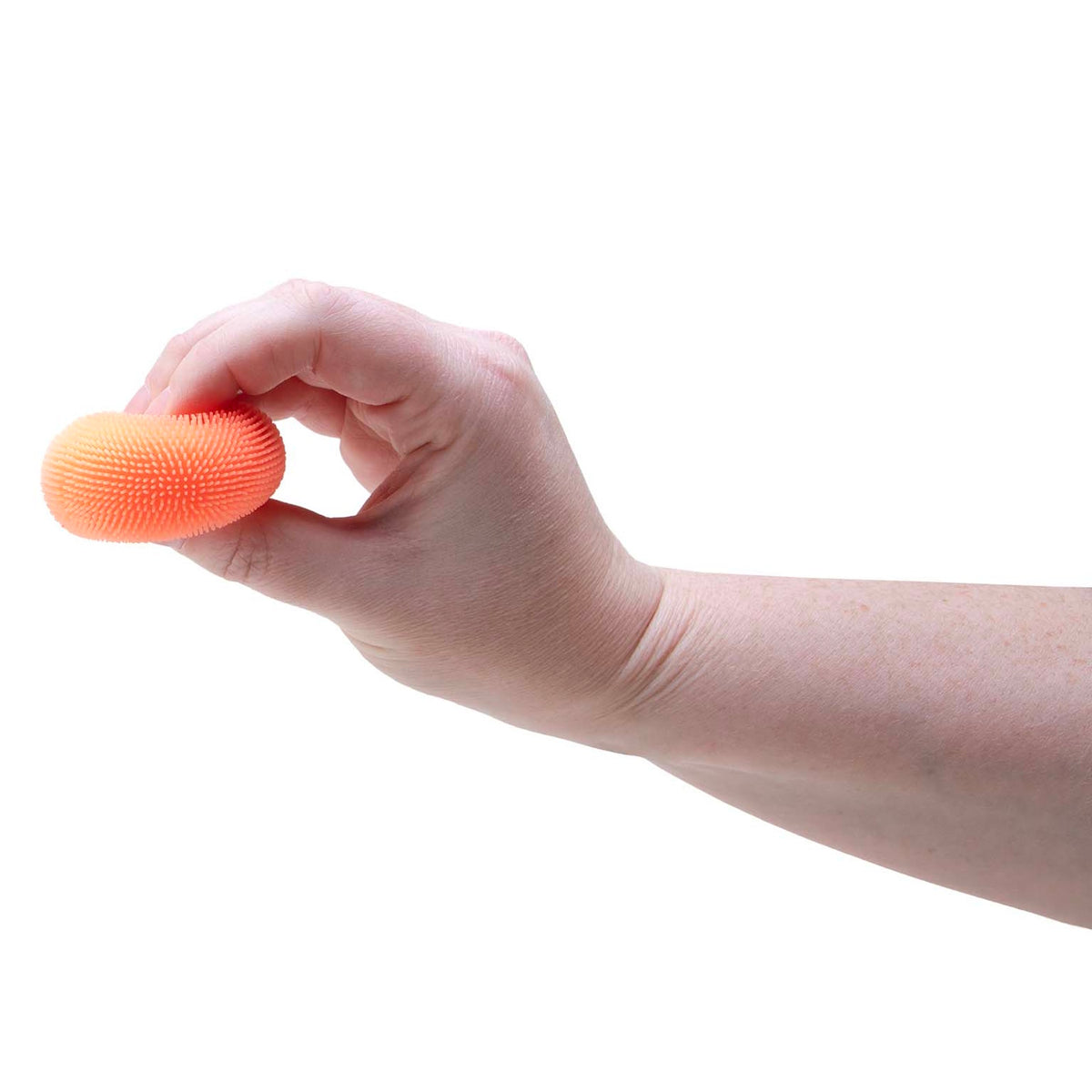 A hand pinching a small, textured orange Teenie NeeDoh Fuzz Ball between fingers against a white background.