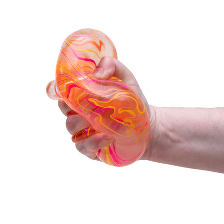 Hand squeezing a NeeDoh Niceberg Swirl stress ball with orange, pink, and yellow marble patterns on a white background.