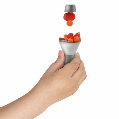 Child's hand holding a miniature lava lamp toy with red and orange floating beads on white background.