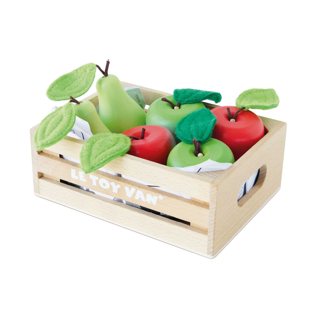 Wooden crate filled with toy apples and pears with felt leaves on a plain background.
