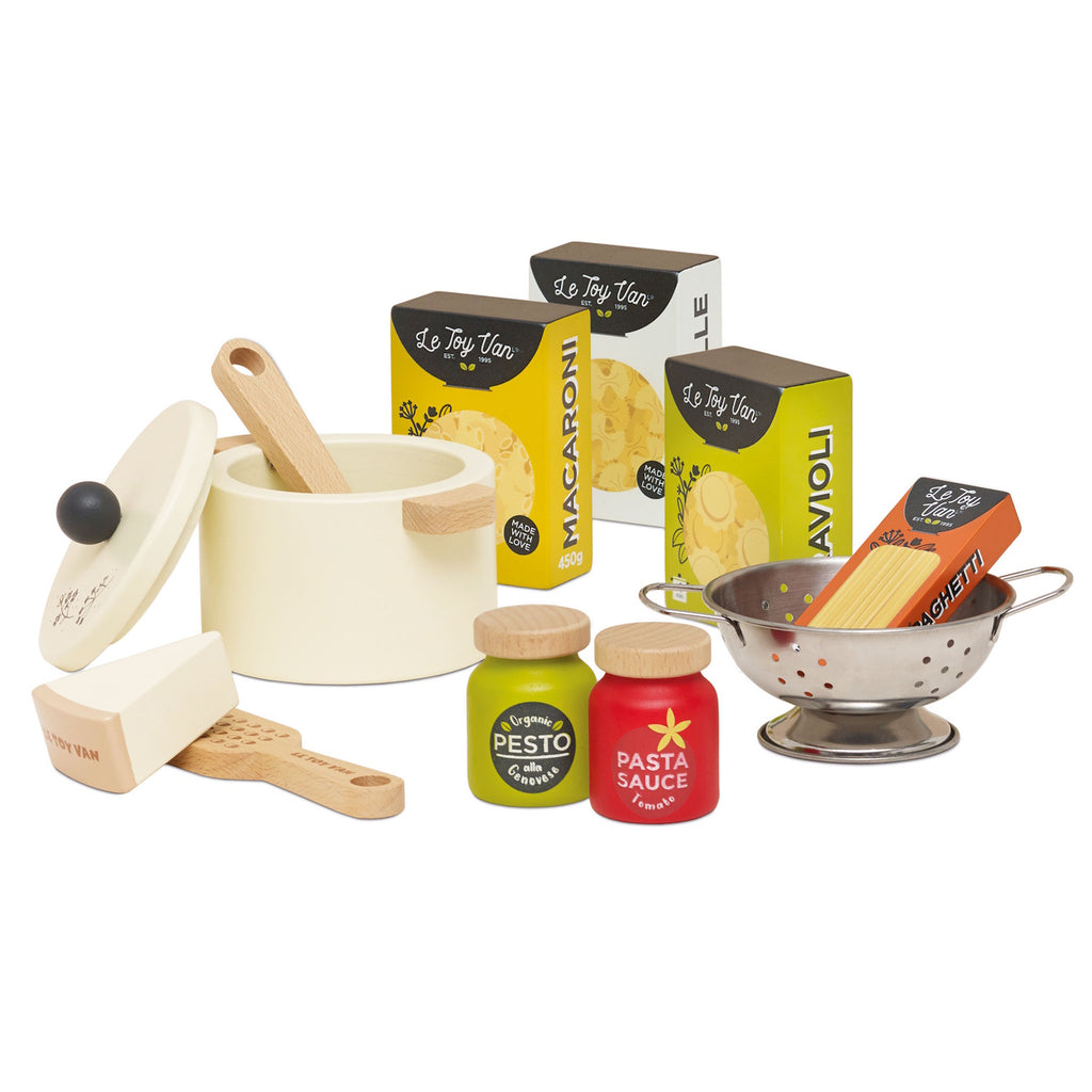 Toy pasta set featuring a cream pot with a lid, wooden spoon, cheese wedge, colander, pesto, and pasta sauce jars, alongside boxed pasta shapes.