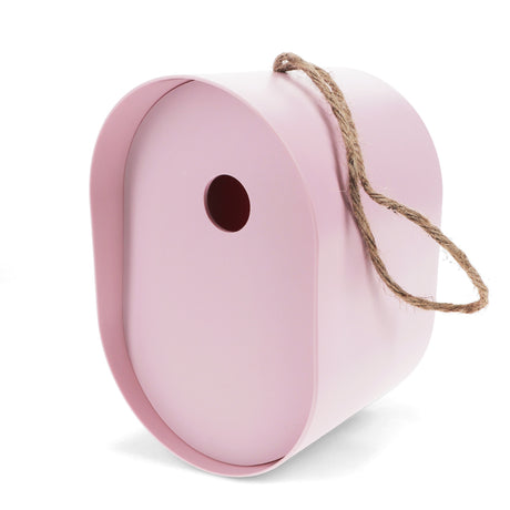 Oval pink bamboo fiber birdhouse with a circular entry hole and a hanging jute rope, shown from a side angle.