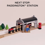 Wooden train pulled up to Paddington station with a Paddington Bear figurine and red post box.