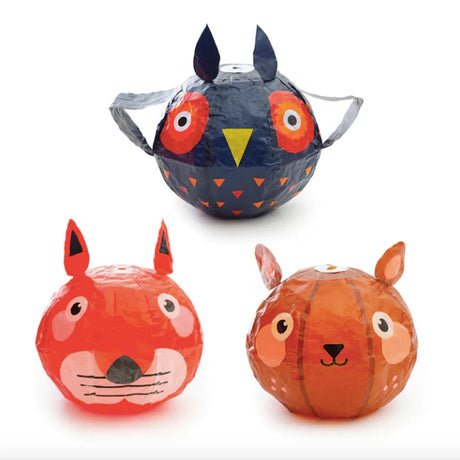 Three animal-themed, colorful paper lanterns are shown: a blue owl with vibrant circles around its eyes, a red fox, and an orange squirrel. Whimsical and playful design.