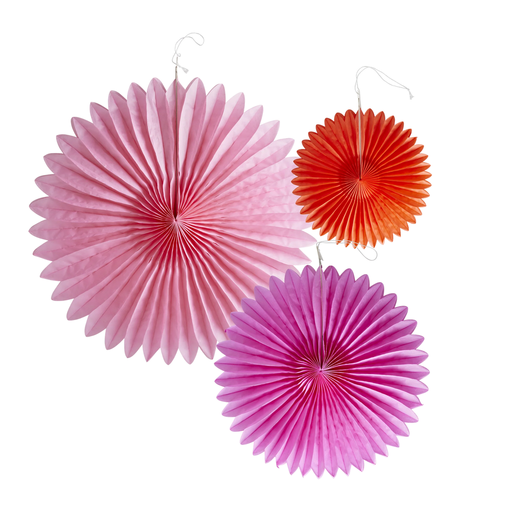 Three colorful paper fans hang against a white background. A large pink, a smaller orange, and a medium purple fan create a festive, vibrant display.