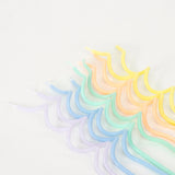 An assortment of colorful, pastel-toned swirly candles in shades of yellow, orange, green, blue, and purple on white background.