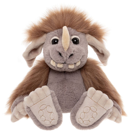 Front view of a grey plush creature with a brown mane, single horn, big feet, and a friendly, toothy grin.